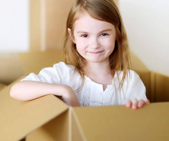 photo of a smiling girl comming out of a moving box